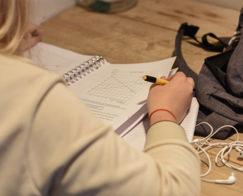 op deze foto is een meisje te zien dat haar huiswerk aan het maken is. Ze is zich aan het voorbereiden voor de examens.